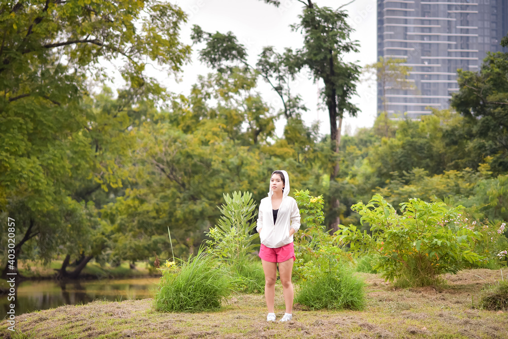 Asian woman is warm up, To make the muscles flexible Before going to jogging for good health and energy metabolism,Outdoors cross training workout. Healthcare concept Asian woman is warm up, To make the muscles flexible Before going to jogging for good health and energy metabolism,Outdoors cross training workout. Healthcare concept