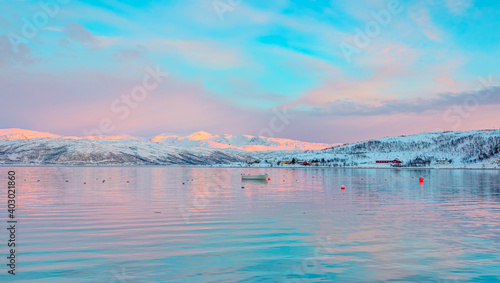 Blue sea with rows of snowy mountains with fjord at amazing sunset - Tromso, Norway