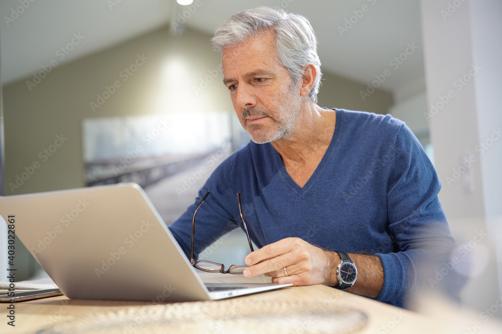Portrait of senior man at home working on laptop Portrait of senior man at home working on laptop