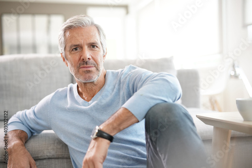 Portrait of attractive senior man with blue sweater relaxing at home