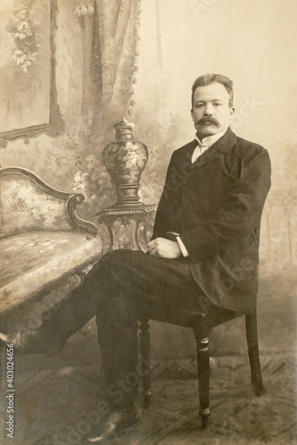 Germany - CIRCA 1910-20s: Rich man sitting in studio. Vintage cabinet card Edwardian era male portrait photo