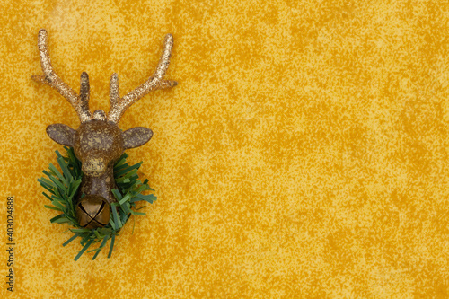 Christmas background with reindeer with wealth and bell on yellow