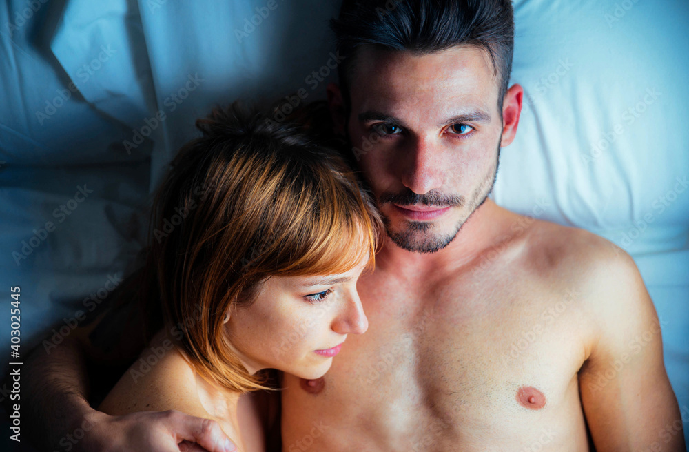 Romantic couple in love lying on the bed together - Boyfriend and girlfriend enjoying Valentine's day