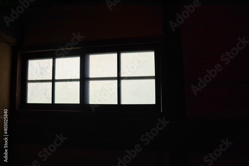 真っ暗な部屋の中から見えるすりガラスの窓
