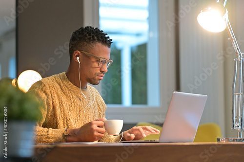 Portrait of african american trendy guy in a distant online call photo