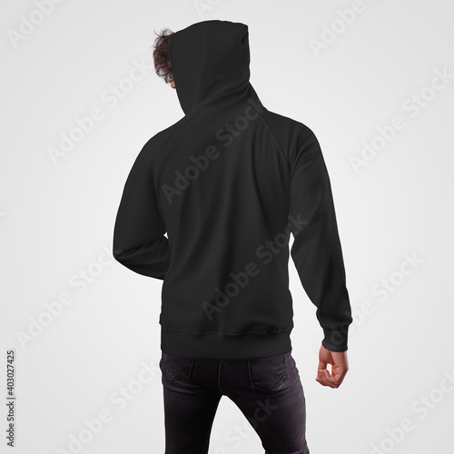 Mockup of a black men's hoodie on a guy in a hood, back view, for presentation of design, pattern.