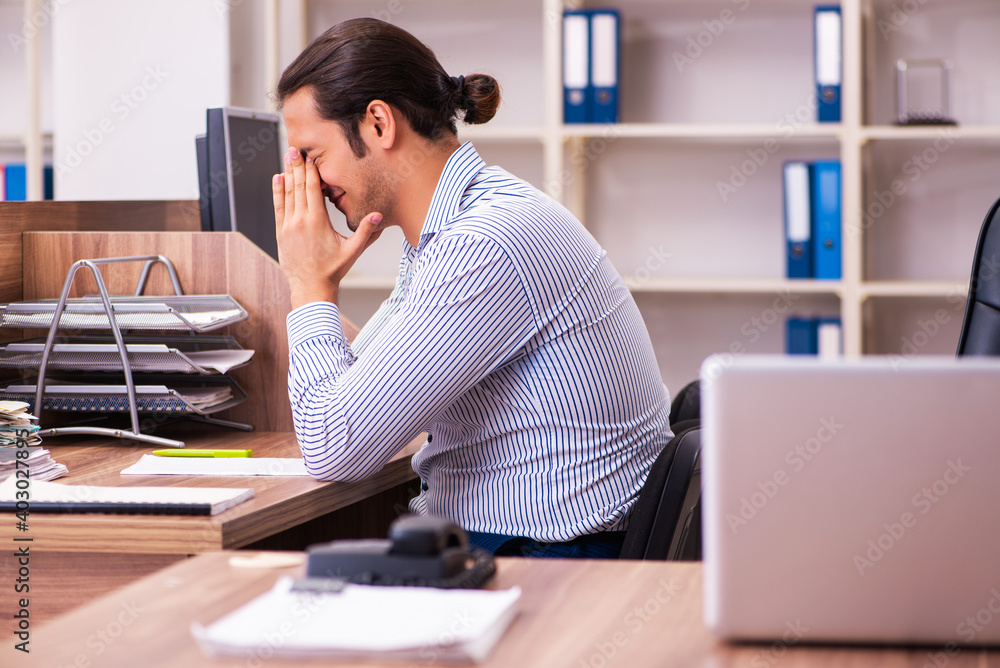 Young male employee working in the office Young male employee working in the office