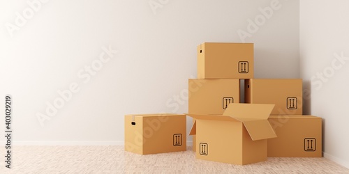 Brown moving storage cardboard boxes closed and open stacked in empty room in apartment or house with wooden floor with copy space © Shawn Hempel