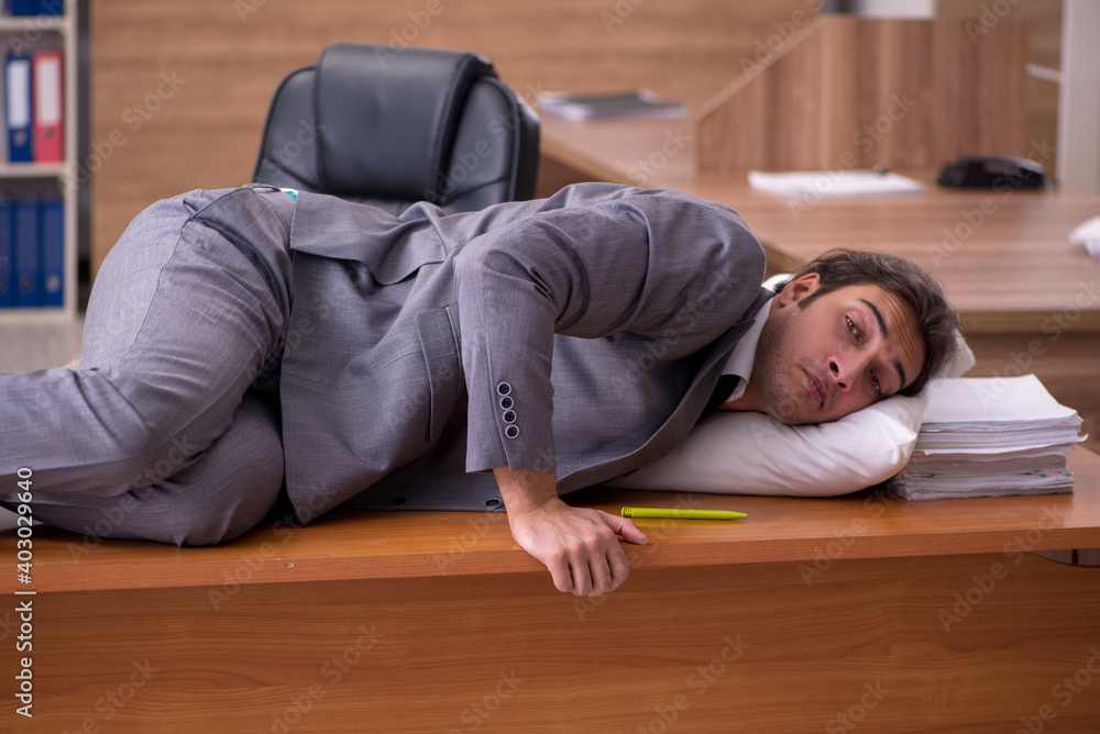 Young male employee sleeping at workplace Young male employee sleeping at workplace