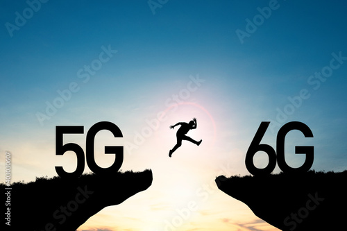 Technology transformation change  from 5G to 6G , Silhouette businessman jumping from 5G cliff to 6G cliff on blue sky. photo