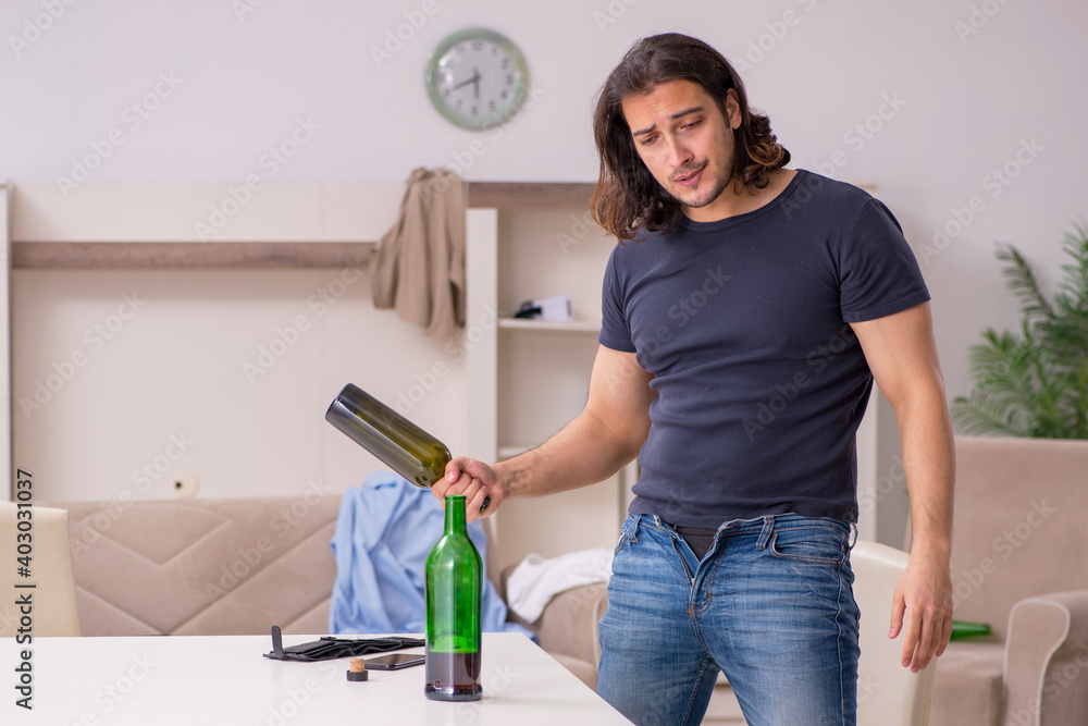 Young unemployed man drinking alcohol at home Young unemployed man drinking alcohol at home