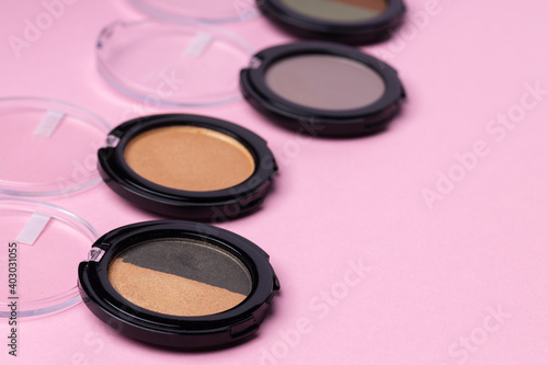 Set of eyeshadows make up products on pink
