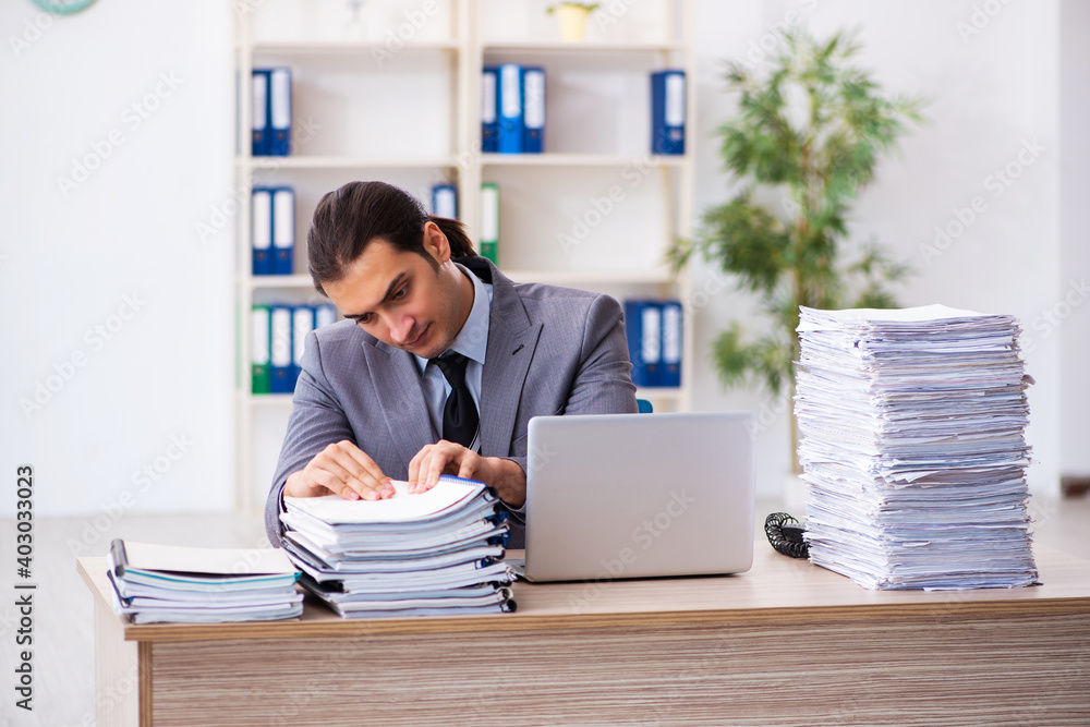 Young male employee unhappy with excessive work Young male employee unhappy with excessive work