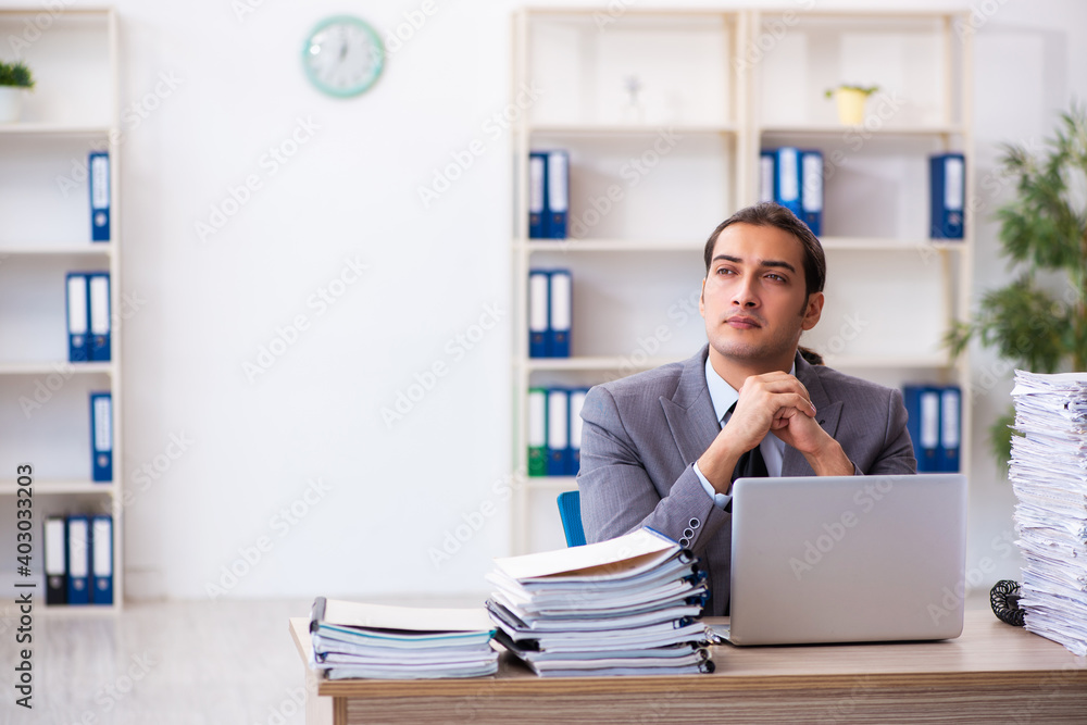 Young male employee unhappy with excessive work Young male employee unhappy with excessive work
