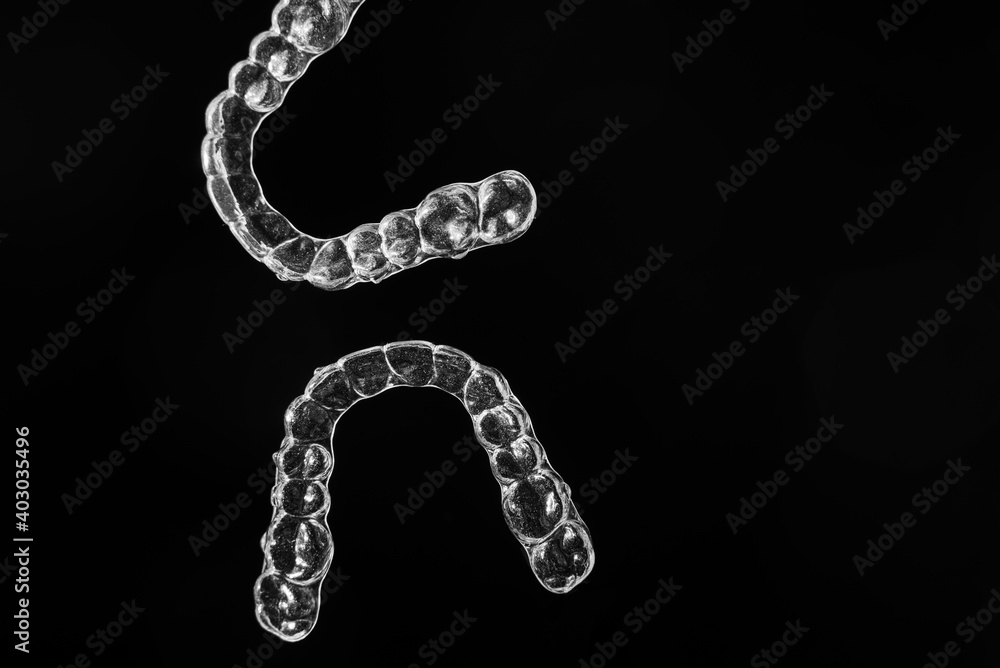 Invisible aligner teeth retainers on a black background Invisible aligner teeth retainers on a black background