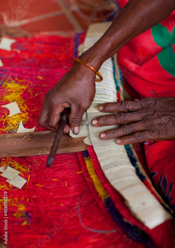 Woman making a traditional skirt with pandanus and banana leaves, Milne Bay Province, Trobriand Island, Papua New Guinea photo