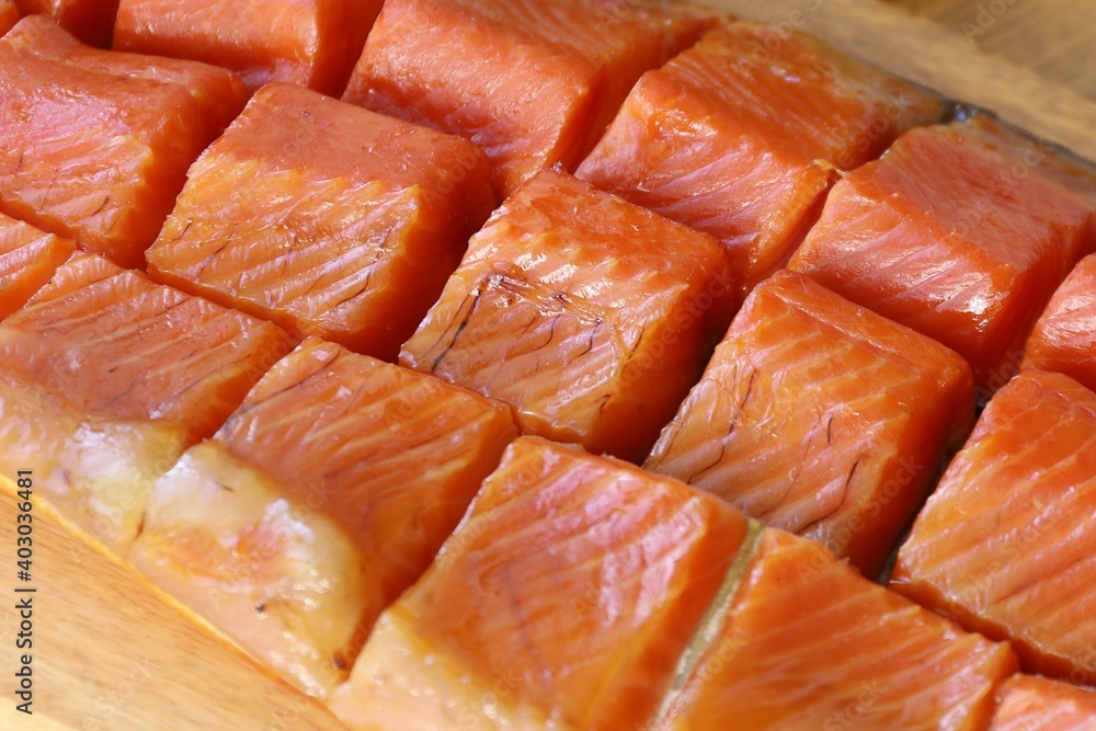pieces of sea trout lie on a black basalt platter next to lemon slices spices and herbs pieces of sea trout lie on a black basalt platter next to lemon slices spices and herbs