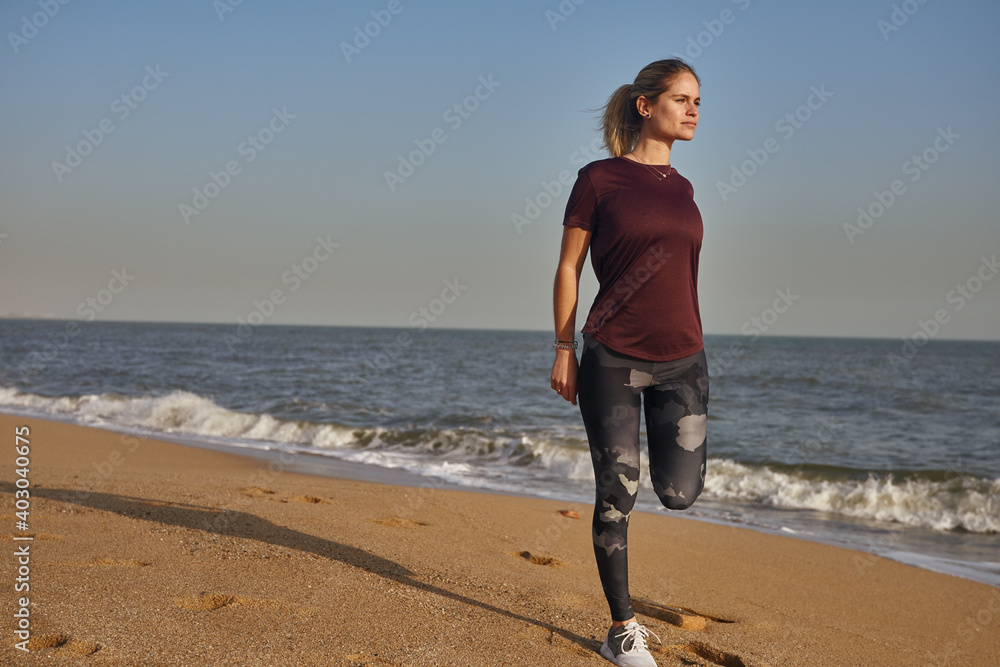 Woman standing on the beach as she exercises