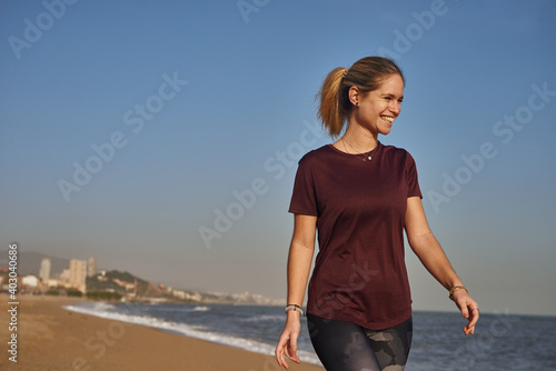 Smiling young woman walking on the beach