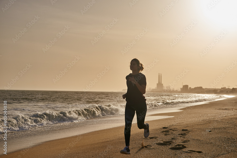 Woman running on a white sandy beach