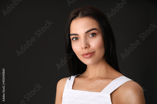 Portrait of beautiful young woman on dark grey background