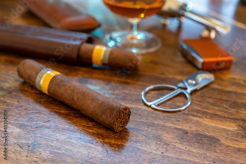 Cuban cigar and smoking accessories on wooden desk