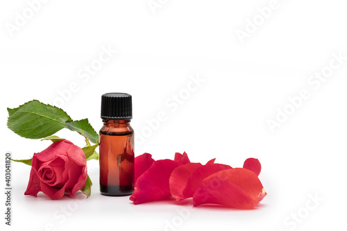 aromatherapy oil bottle with rose flower and petals