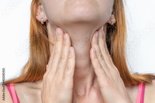 Woman with throat sore is holding her aching throat