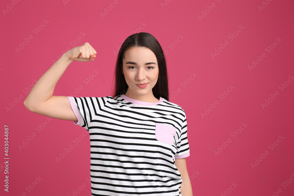 Strong woman as symbol of girl power on pink background. 8 March concept Strong woman as symbol of girl power on pink background. 8 March concept