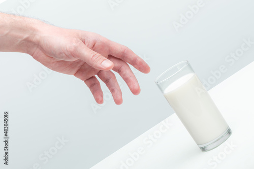 Hand of a man reaching for a glass of milk