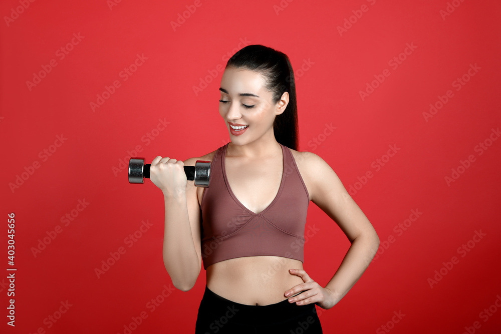 Woman with dumbbell as girl power symbol on red background. 8 March concept Woman with dumbbell as girl power symbol on red background. 8 March concept