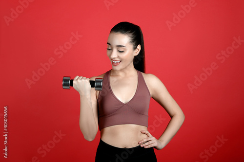 Woman with dumbbell as girl power symbol on red background. 8 March concept © New Africa