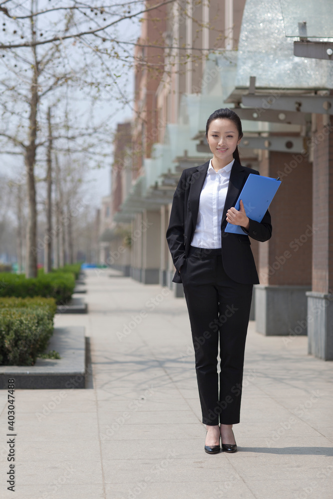 The young beauty works outdoors with documents The young beauty works outdoors with documents