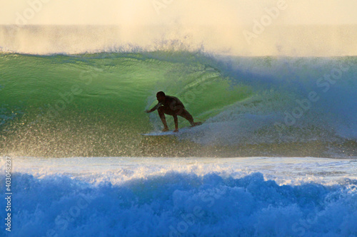 Tablou pe pânză Surfer reitet eine grüne Welle in der goldenen Stunde vor Sonnenuntergang in Kap