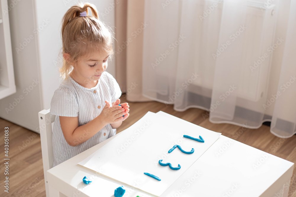 Child preschooler making a numbers from plasticine. Home education. Child preschooler making a numbers from plasticine. Home education.