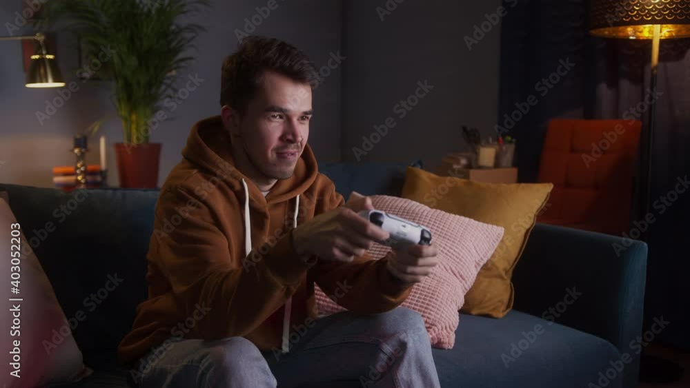 Excited man playing video games on modern next gen console with gamepad 2020, new era of consoles, white gamepad, male at home play games Excited man playing video games on modern next gen console with gamepad 2020, new era of consoles, white gamepad, male at home play games