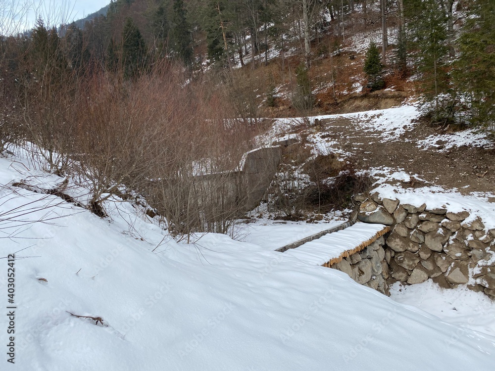 Schneeschuhwandern am Achensee Pertisau im Gerntal Pletzach in der Nähe von Schwaz Innsbruck Tirol Grenze zu Bayern am späten Nachmittag im Winter an einem Wehr im vereisten Bachbett