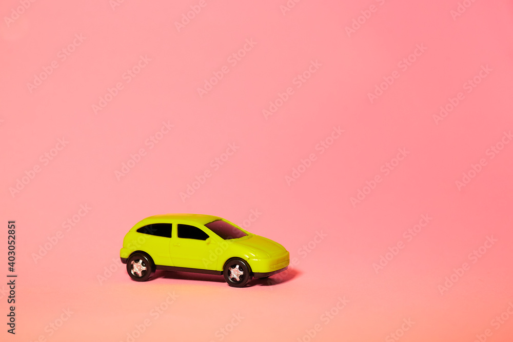 yellow toy car on pink background, concept idea of taxi and cargo delivery during quarantine yellow toy car on pink background, concept idea of taxi and cargo delivery during quarantine