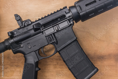 Loaded AR-15 semi-auto assault rifle gun on a wooden background with a 30 round magazine