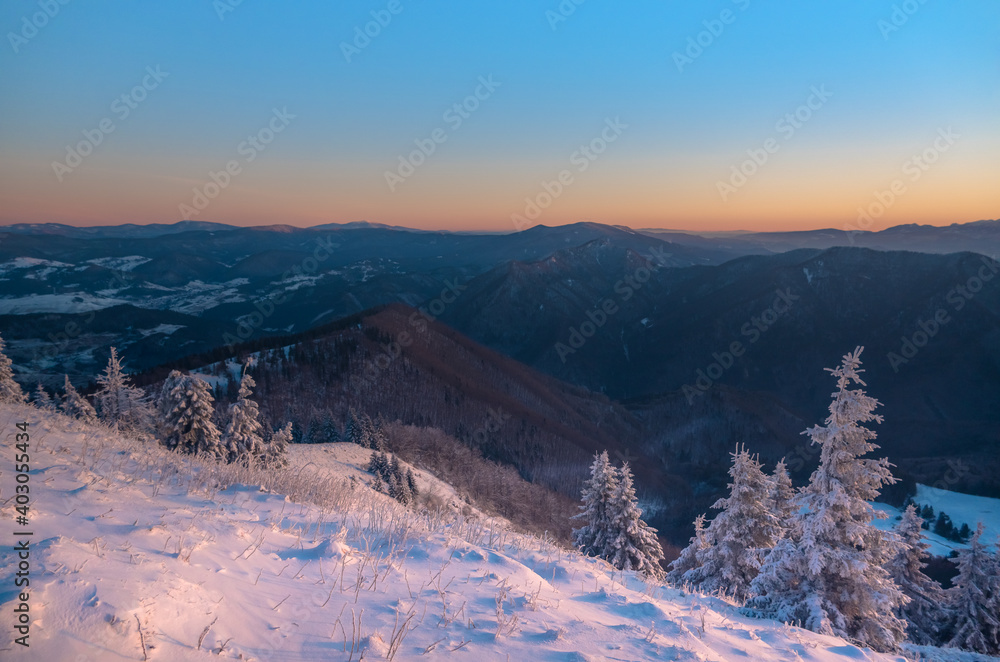 Wonderful sunrise light in wild winter nature and snow cover on mountain peaks in alpine mountains