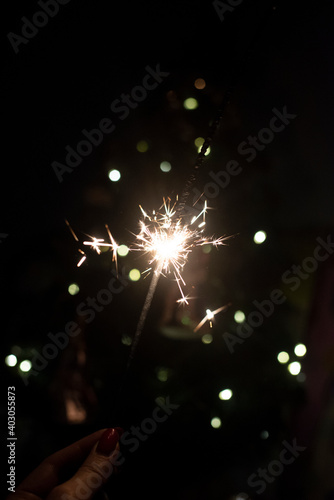 A burning sparkler on a glitter background