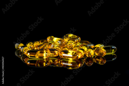 Fish oil capsules on a black background. Theme of health