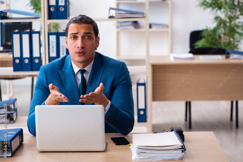 Young handsome employee sitting in the office Young handsome employee sitting in the office