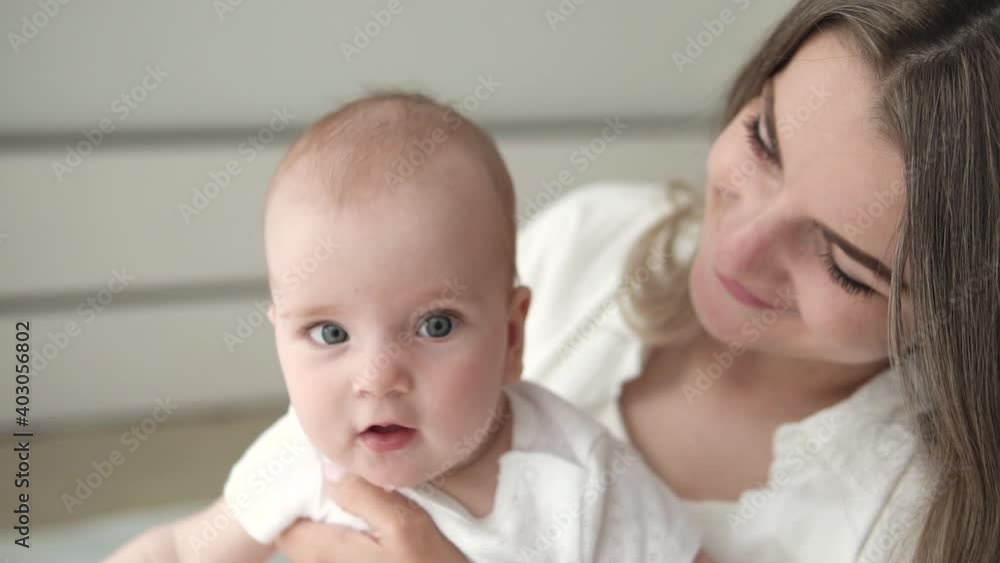 Pretty young mother kissing in head her cute little baby girl, love, slow motion Pretty young mother kissing in head her cute little baby girl, love, slow motion