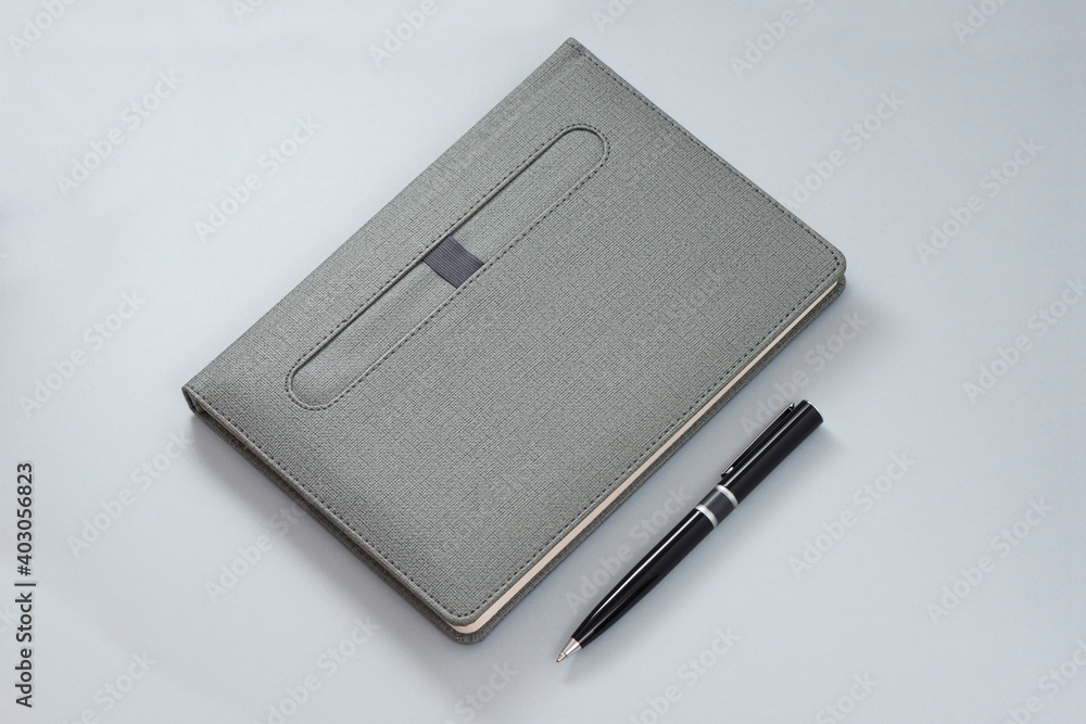 Gray notebook and black pencil an the gray background. Gray notebook and black pencil an the gray background.