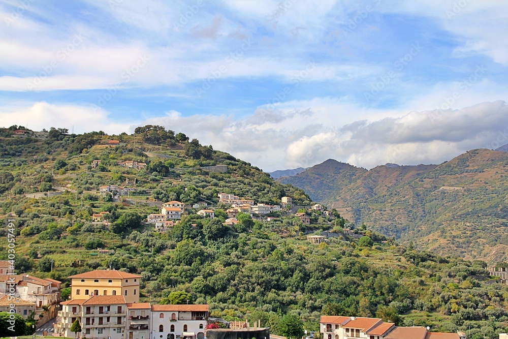 mountains, valleys, hills with vegetation and houses built on the hills, the sky with clouds, Sicily, Italy
