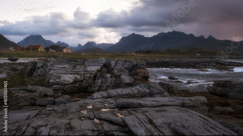 rocky coast of the north sea in Norway on the Lofoten Islands against the backdrop of mountains and fishing village