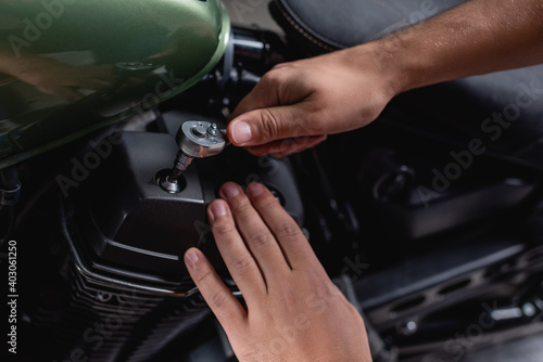 cropped view of mechanic using socket wrench while making diagnostics of motorcycle in workshop © LIGHTFIELD STUDIOS