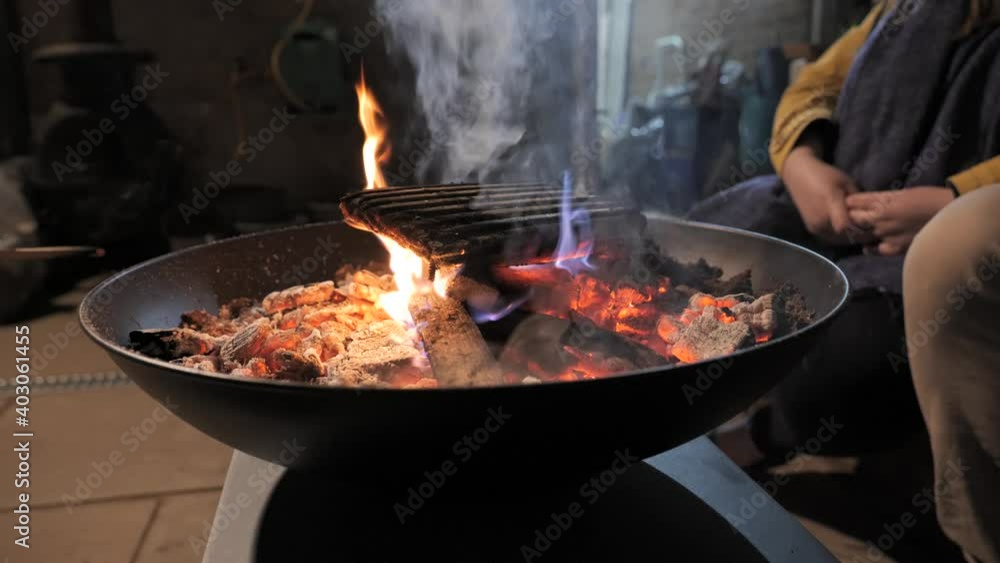 People sitting around a firepit on a patio. People sitting around a firepit on a patio.