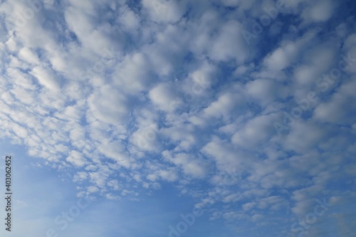 Clear blue sky with white clouds in summer time. Nature background concept.